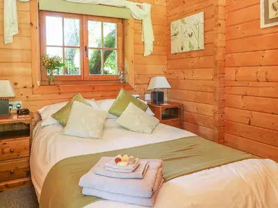 a bedroom with a bed in a log cabin at Pond Cabin in Stithians