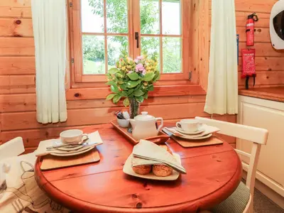 a wooden table with a plate of food on it at Pond Cabin in Stithians
