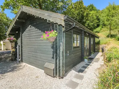 a small shed with a flower pot on it at Pond Cabin in Stithians