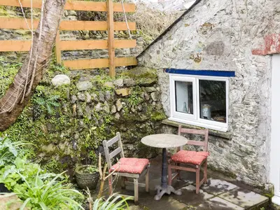 a table and two chairs in front of a building at The Old Sweet Shop in Par