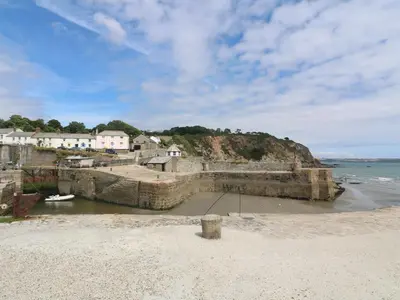 a sandy beach with houses and the ocean at The Old Sweet Shop in Par