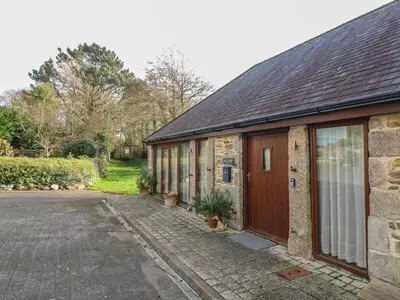 a brick building with a door and a driveway at Willow in Falmouth