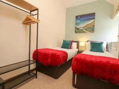 a bedroom with two beds with red sheets at Willow in Falmouth