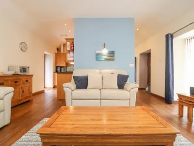 a living room with a couch and a table at Willow in Falmouth