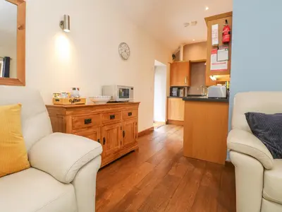 a living room with two chairs and a kitchen at Willow in Falmouth