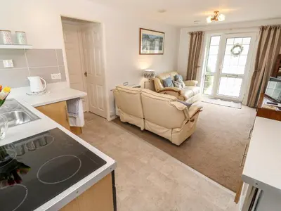 a kitchen and a living room with a couch at Brook Haven in Saint Cleer