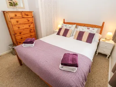 a bedroom with a large bed with two towels on it at Brook Haven in Saint Cleer