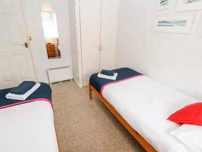 two twin beds in a room with a mirror at Brook Haven in Saint Cleer
