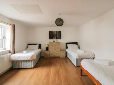 a room with two beds and a dresser in it at 4 Bredon Court in Newquay