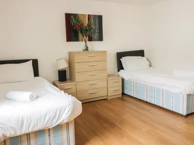 a bedroom with two twin beds and a dresser at 4 Bredon Court in Newquay