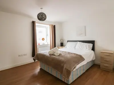 a bedroom with a large bed and a window at 4 Bredon Court in Newquay