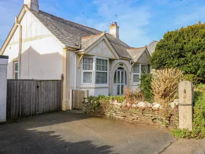 a white house with a gate and a fence at Pound Rocks in Tintagel