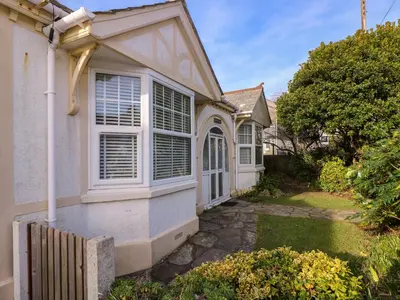 a white house with a window and a fence at Pound Rocks in Tintagel
