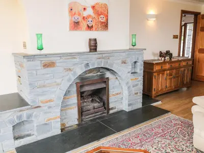 a stone fireplace in a living room with a couch at Higher Kernick Farm in Launceston