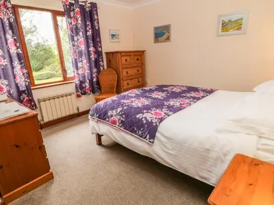 a bedroom with a bed and a dresser and a window at Higher Kernick Farm in Launceston