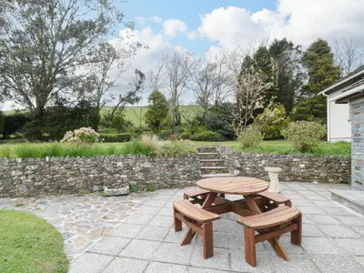a picnic table and benches on a patio at Higher Kernick Farm in Launceston