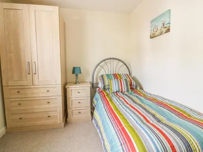 a bedroom with a bed and a dresser and a cabinet at 12 Kel Avon in Truro