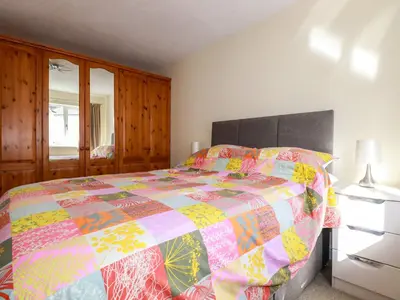 a bedroom with a bed with a colorful quilt at 12 Kel Avon in Truro