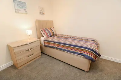 a small bedroom with a bed and a night stand at 12 Kel Avon in Truro