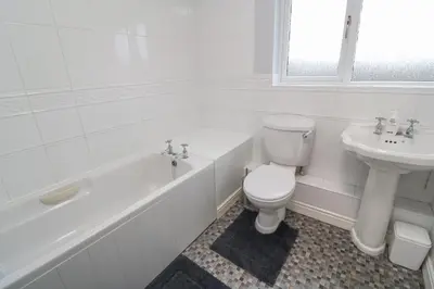 a white bathroom with a toilet and a sink at 12 Kel Avon in Truro