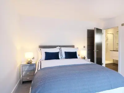 a bedroom with a large bed with blue pillows at An Drowes in Newquay