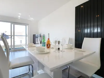 a white dining room table with chairs and wine bottles at An Drowes in Newquay