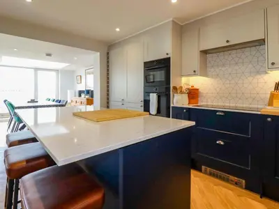 a kitchen with blue cabinets and a white counter top at Pink House in Mevagissey