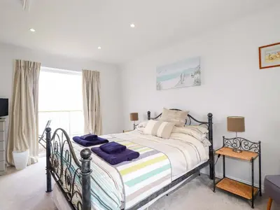 a bedroom with a bed and a window at Pink House in Mevagissey