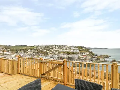 a wooden balcony with a view of a city at Pink House in Mevagissey