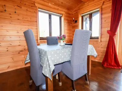 a dining room with a table and chairs in a cabin at Willow Lodge in Bodmin