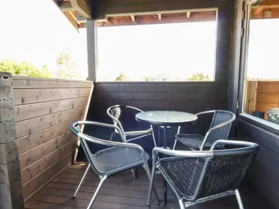 a patio with chairs and a table on a deck at Hazel Lodge in Bodmin