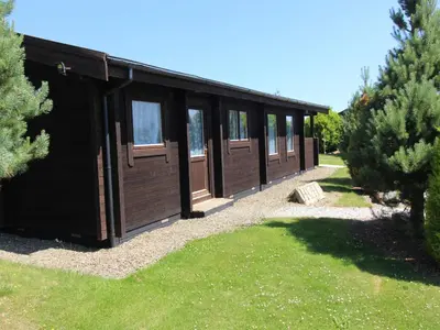 a black building with windows in a yard at Hazel Lodge in Bodmin