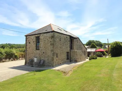 an old stone building in a field with grass at Sunnywell in Bodmin