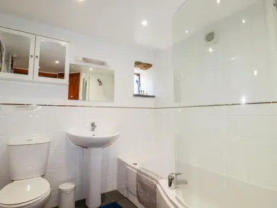 a white bathroom with a toilet and a sink at Sunnywell in Bodmin