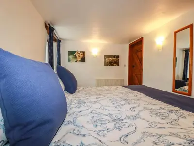 a bedroom with a bed with a blue and white bedspread at Sunnywell in Bodmin