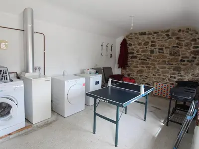 a laundry room with a table and washing machines at Sunnywell in Bodmin