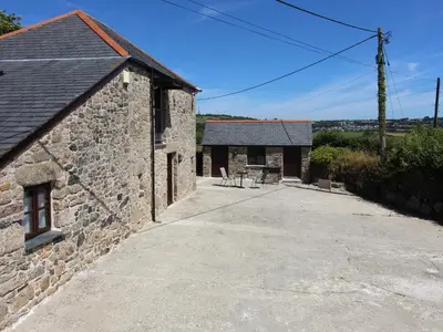 an external view of a stone building with a patio at Sunnywell in Bodmin