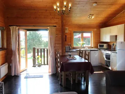 a kitchen with a dining table in a cabin at Cherry Lodge in Bodmin