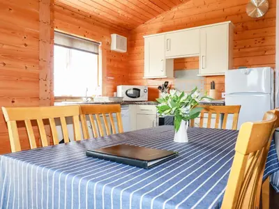 a dining room table with a blue and white table cloth at Maple Lodge in Bodmin