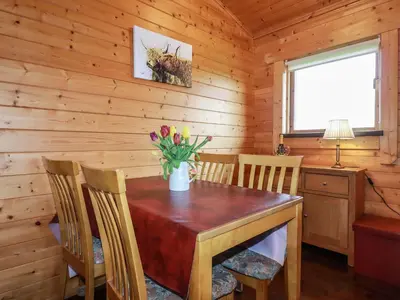a dining room with a wooden table and chairs at Cedar Lodge in Bodmin