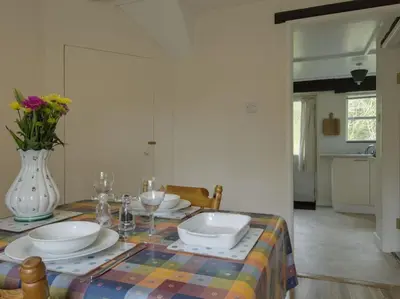 a table with plates and glasses and a vase at The Old Engine House in Bodmin