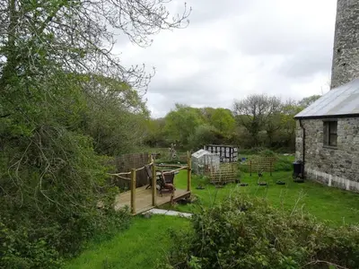 a garden with a wooden deck and a building at The Old Engine House in Bodmin
