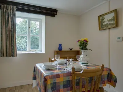 a dining room table with a table cloth and glasses at The Old Engine House in Bodmin