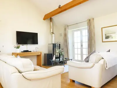 a living room with two white couches and a tv at Atlantic View in Tintagel