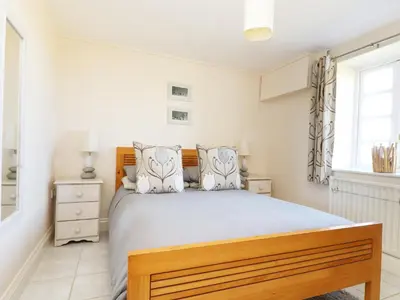 a bedroom with a large bed and a window at Atlantic View in Tintagel