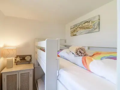 a bedroom with two bunk beds and a nightstand at Atlantic View in Tintagel