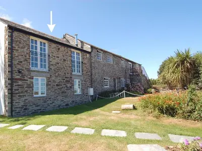a brick building with a yard in front of it at Atlantic View in Tintagel