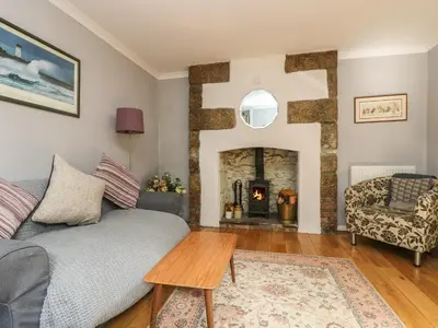 a living room with a couch and a fireplace at Primrose Cottage in Penryn
