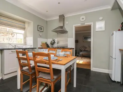 a kitchen and dining room with a table and chairs at Primrose Cottage in Penryn
