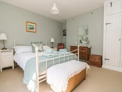 a bedroom with a bed and a nightstand and a bed sidx sidx sidx sidx at Primrose Cottage in Penryn